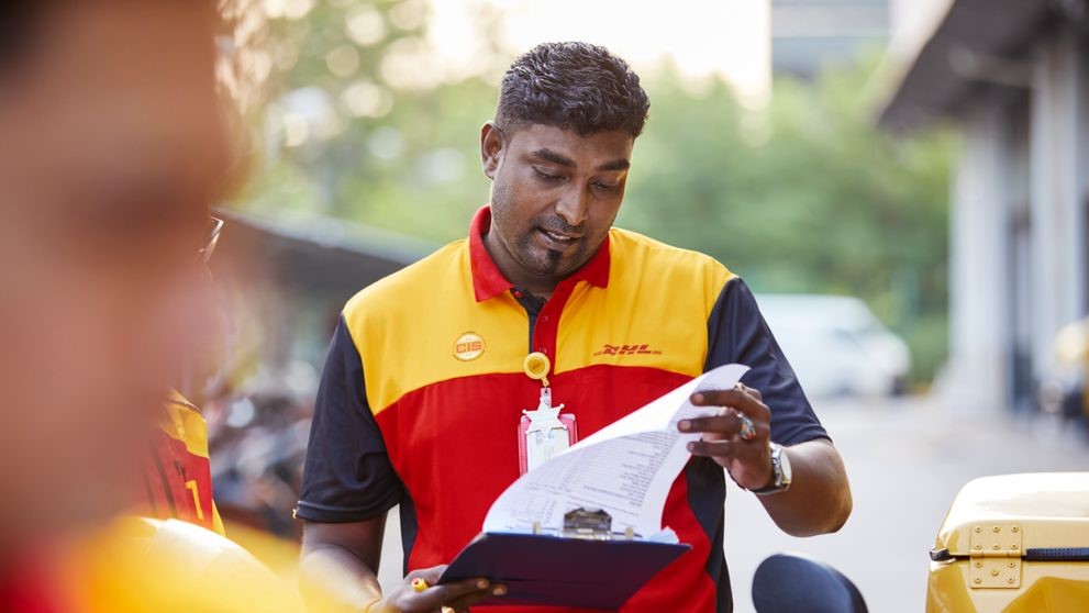 dhl express employee flipping through paperwork